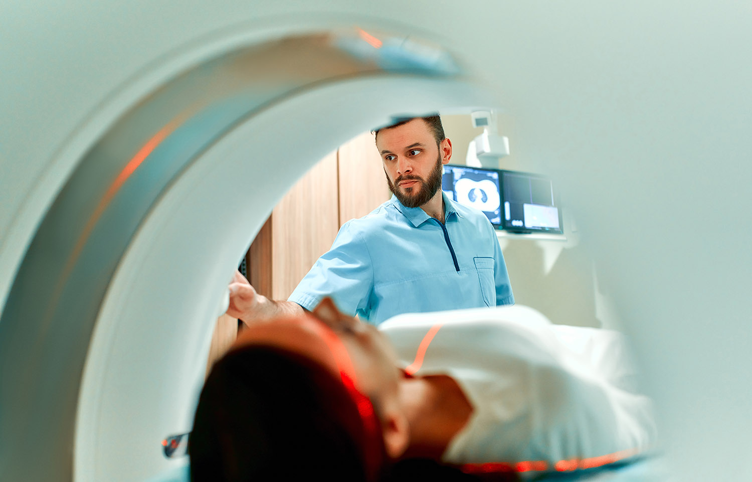 A patient lying on CT or MRI, the bed moves inside the machine, AdobeStock 425084101