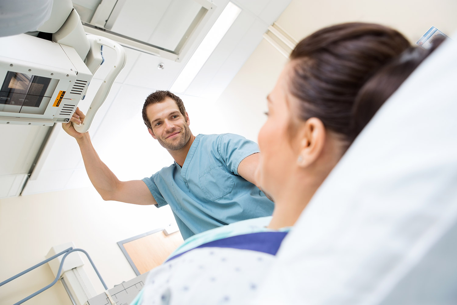 Male Nurse Adjusting Xray Machine For Patient AdobeStock 59051150