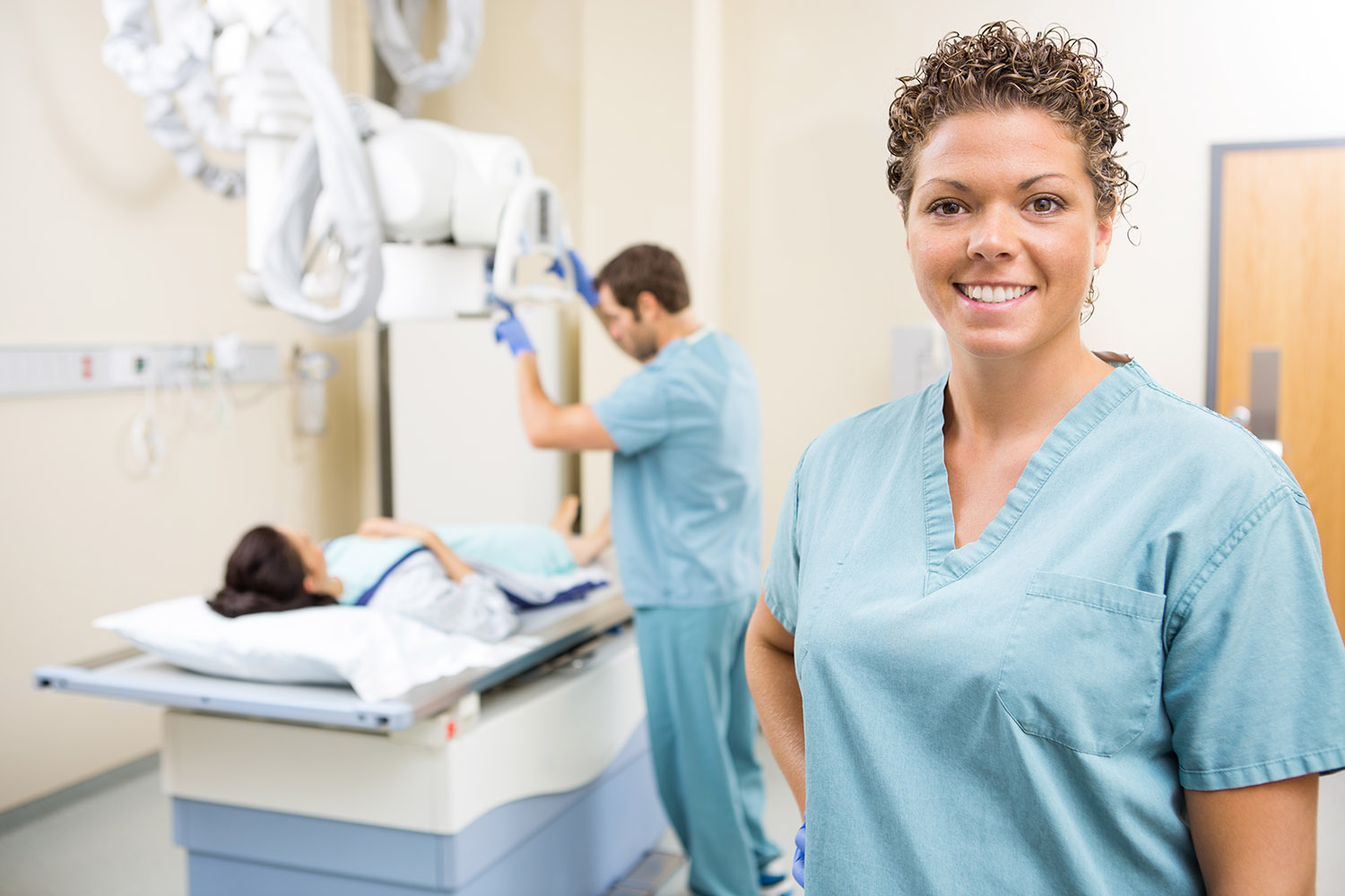 Nurse Smiling While Colleague Preparing Patient For Xray AdobeStock 59210572