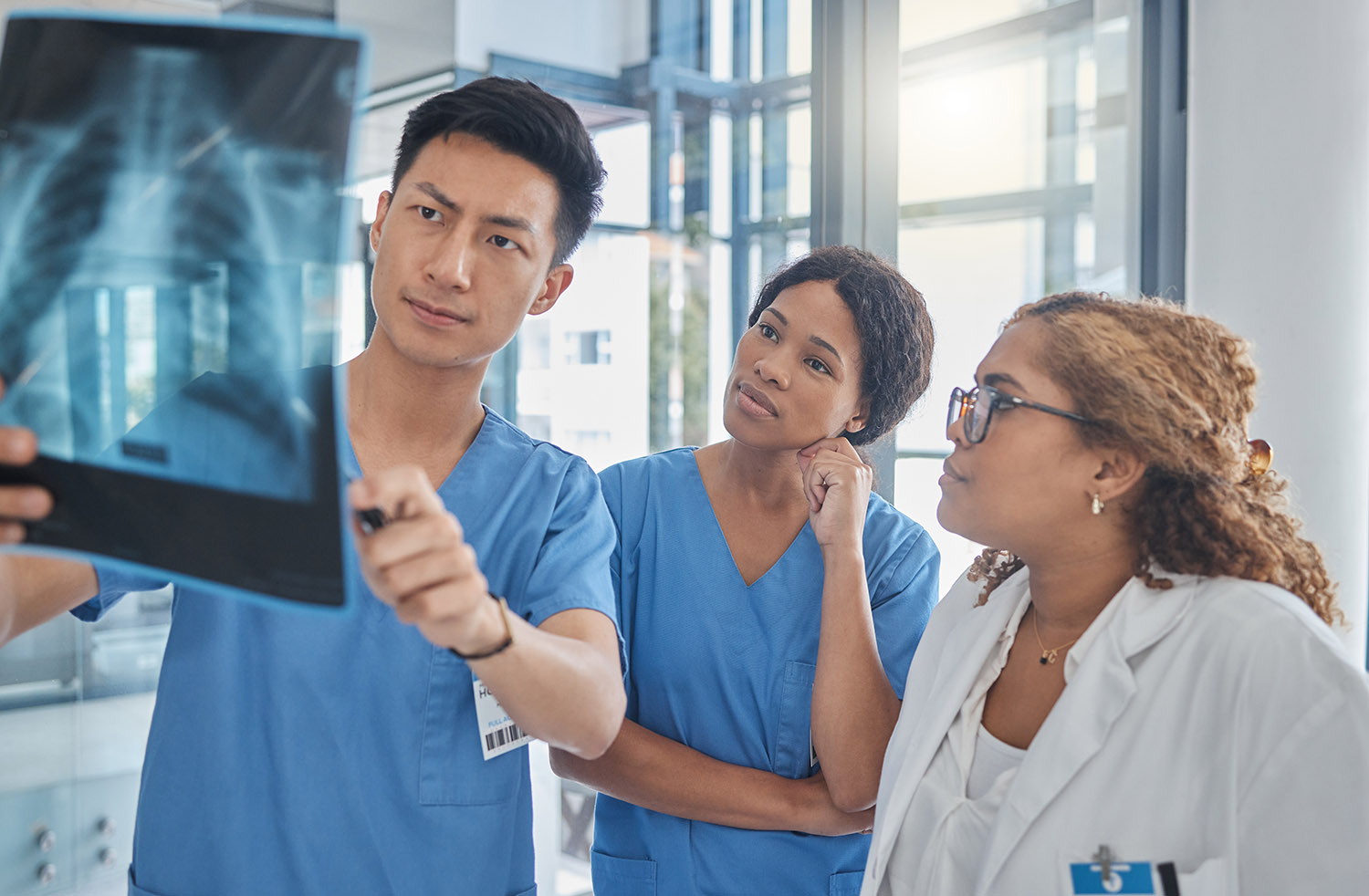 Results, xray and doctors with surgeon for teamwork, research and analysis for solution in hospital. Review, radiology and medical women with man for talking, medicine or planning for lungs treatment AdobeStock 971707585
