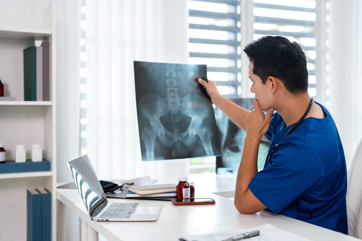 Doctor radiology holding x-ray film , reviewing patient diagnosis results in clinic. Doctor radiology holding x-ray film , reviewing patient diagnosis results in clinic.